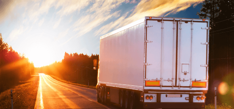 Truck driving into a sunset