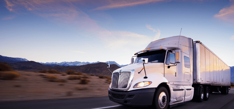 White truck driving through desert